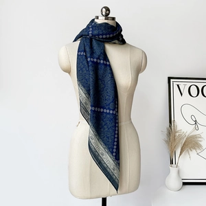 Dettaglio di sciarpa in seta blu scuro con stampe paisley vintage e motivi floreali