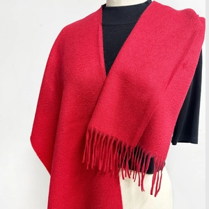 Detail showing high-quality solid red wool scarf with fine tassels and soft texture
