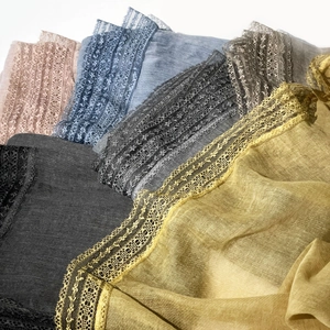 Close-up of thin cotton linen scarves with elegant lace edges in multiple colors