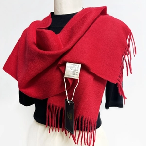 Detailed shot of a red Australian wool scarf showing fringe edges and fabric care label