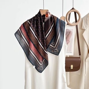 Gros plan d'un foulard carré en soie avec imprimés équestres et motifs de chaînes sur mannequin