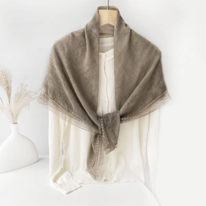 Close-up of the delicate lace edge on a taupe cotton linen scarf for women