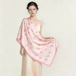 Détail d'une écharpe en soie rose avec motifs de tulipes et texture fluide et lisse