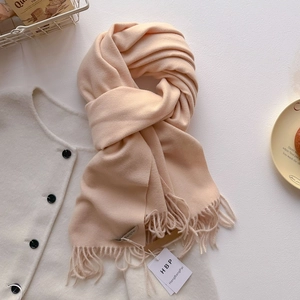 Détail d'une écharpe douce au toucher cachemire avec franges et étiquettes de marque