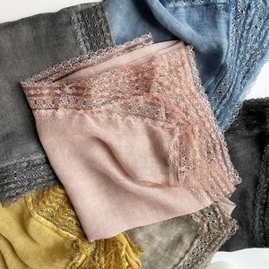 Close-up of lightweight cotton linen scarf showing delicate lace trim in various colors