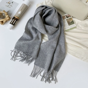 Detailed close-up of light grey 100% Australian wool scarf featuring elegant fringe tassels