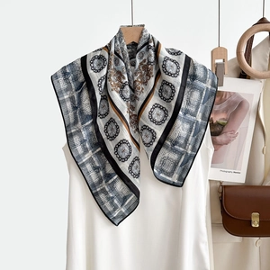 Détail d'un foulard en soie vintage à chevrons avec bordure géométrique et texture satinée