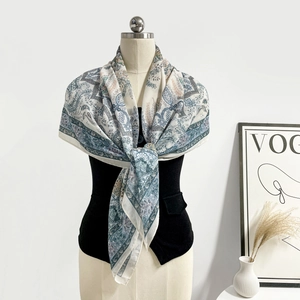 Dettaglio di sciarpa bohémien con stampa paisley indossata come scialle su gilet
