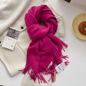 Gros plan d'une écharpe magenta douce aspect cachemire avec franges et étiquette