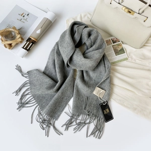 Close-up of premium gray 100% Australian wool scarf with soft tassels and fabric tags