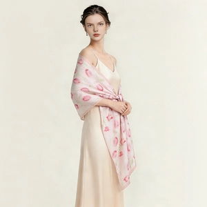 Détail d'un foulard en satin rose clair avec imprimé tulipes porté comme un châle chic
