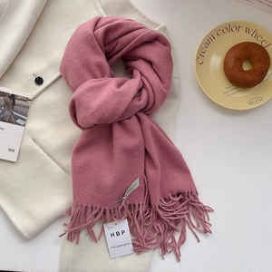 Détail de l'écharpe rose doux style cachemire avec franges et emballage cadeau élégant