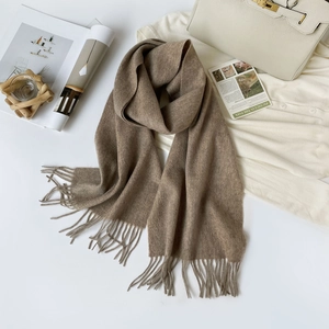 Detail of pure camel wool scarf with elegant tassels and soft premium texture