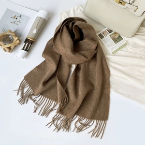 Detailed flat lay of a brown wool scarf with tassels and elegant fashion accessories