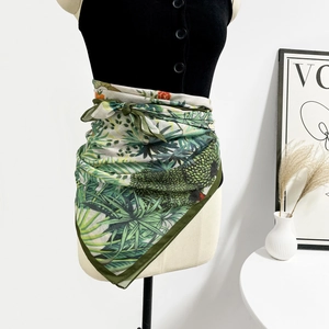 Dettaglio di un foulard in seta con foglie tropicali usato come cintura su un manichino