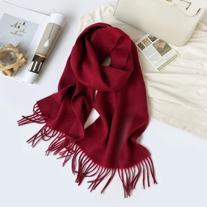 Detail of burgundy Australian sheep wool scarf with long tassels on white backdrop