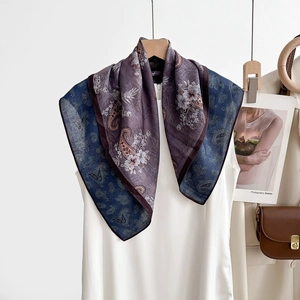 Gros plan détaillé du motif cachemire et de la texture florale sur foulard en soie violet