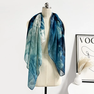Dettaglio della sciarpa in chiffon leggero semitrasparente con sfumatura blu-verde