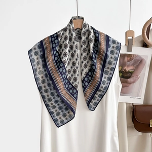 Détail d'un foulard en soie vintage à motif géométrique drapé sur une robe blanche élégante