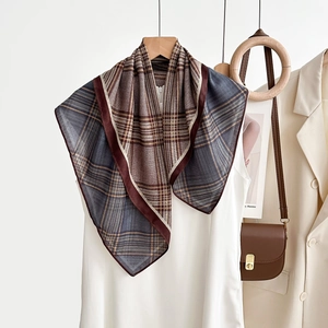 Détail d'un foulard vintage à chevrons stylisé avec un sac à main en cuir marron