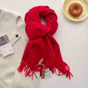 Détail de l'écharpe rouge à franges avec texture et étiquette de marque incluse