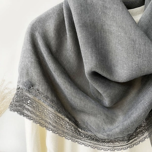 Close-up of elegant grey cotton linen scarf featuring delicate black lace border detailing