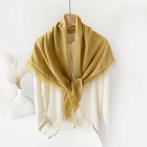 Detail of bright yellow lace edge scarf showing delicate embroidery and soft linen texture
