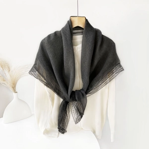 Close-up of dark grey linen scarf with intricate black lace trim and lightweight texture