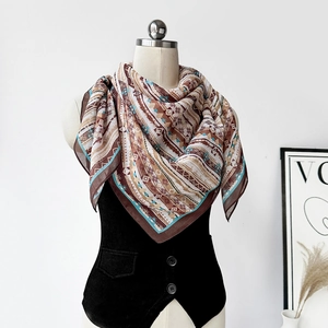 Dettaglio di un foulard di seta boho con motivi geometrici su un manichino da esposizione