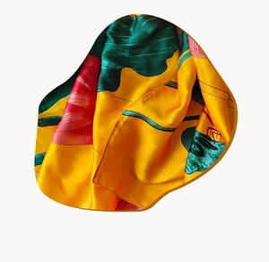 Detail of silk scarf showing red lotus pattern and yellow satin texture with smooth finish