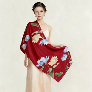 Detailed texture of red silk scarf featuring elegant lotus flower patterns and smooth finish