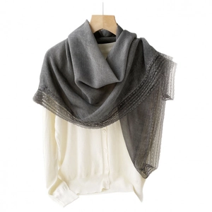 Dark grey cotton linen scarf with elegant lace trim draped over a white knit cardigan