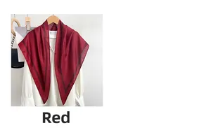 Detail of red silk scarf with black stripe edge draped elegantly on a white shirt collar