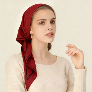 Detail of elegant wine red silk scarf with black striped edges tied in a vintage head style