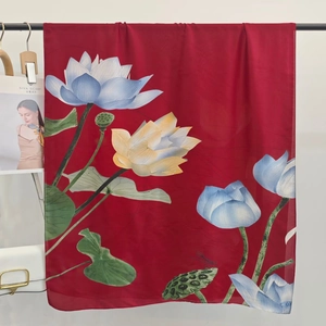 Detailed macro view of bright red satin scarf with elegant blue and yellow lotus pattern