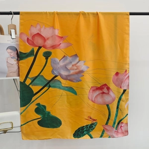 Detail of elegant yellow silk scarf featuring lotus patterns and dragonfly prints