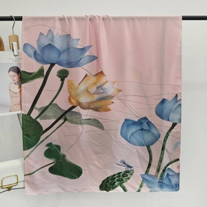 Detailed close-up of pink silk scarf with floral lotus and dragonfly patterns