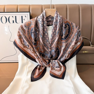 Close-up of elegant paisley print silk scarf in pink and brown with chic bow styling