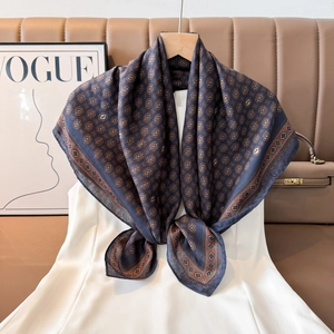 Detail view of retro geometric pattern silk scarf styled on a white summer dress
