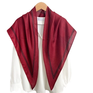 Elegant deep red silk scarf with black striped edges styled on a white shirt