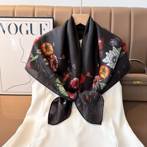 Detail of floral printed silk scarf with colorful poppy and daisy pattern on black fabric