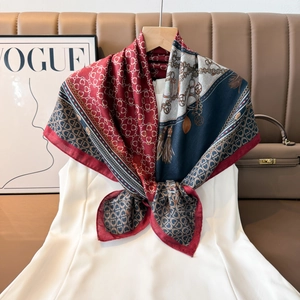 Detail of red and navy silk scarf with equestrian chain patterns and geometric texture