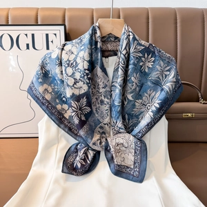 Detail of vintage floral print silk scarf in blue and white draped on a white dress