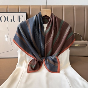 Detailed view of paisley silk scarf with herringbone pattern and orange border trim