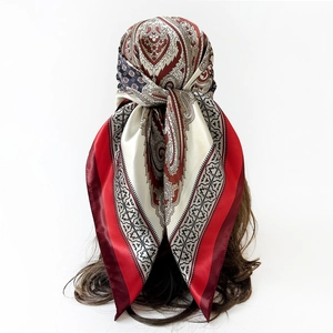 Detail of red paisley satin scarf shown as a headwrap on a model with glossy finish