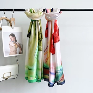 Detail of premium silk scarves with vibrant floral patterns and elegant hemmed edges