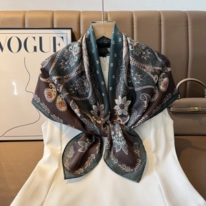 Detail of vintage paisley silk scarf with elegant pattern on white dress