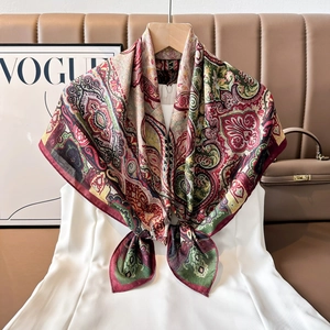 Close-up of vintage paisley pattern on a luxurious burgundy and green silk scarf