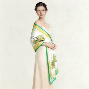 Detail of silk scarf with floral print and green border worn as a beach shawl