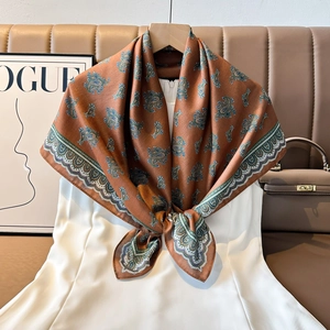 Detail of vintage paisley silk scarf styled on white dress with elegant drape